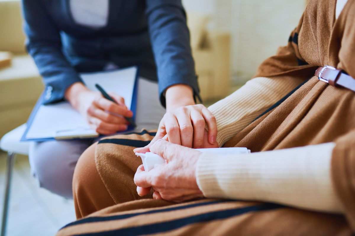 le mani di una psicologa che consolano una persona
