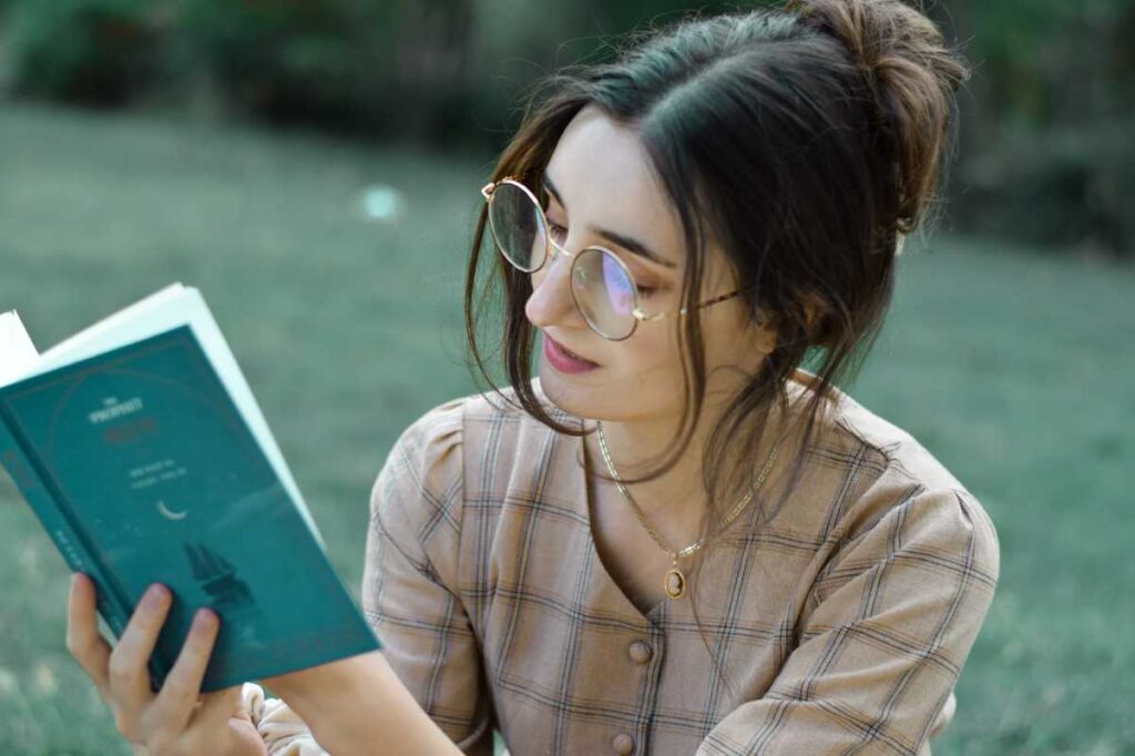Donna che legge un libro sul prato
