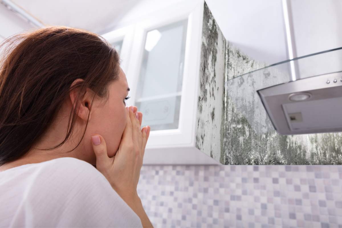 donna di spalle guarda muffa sulle pareti