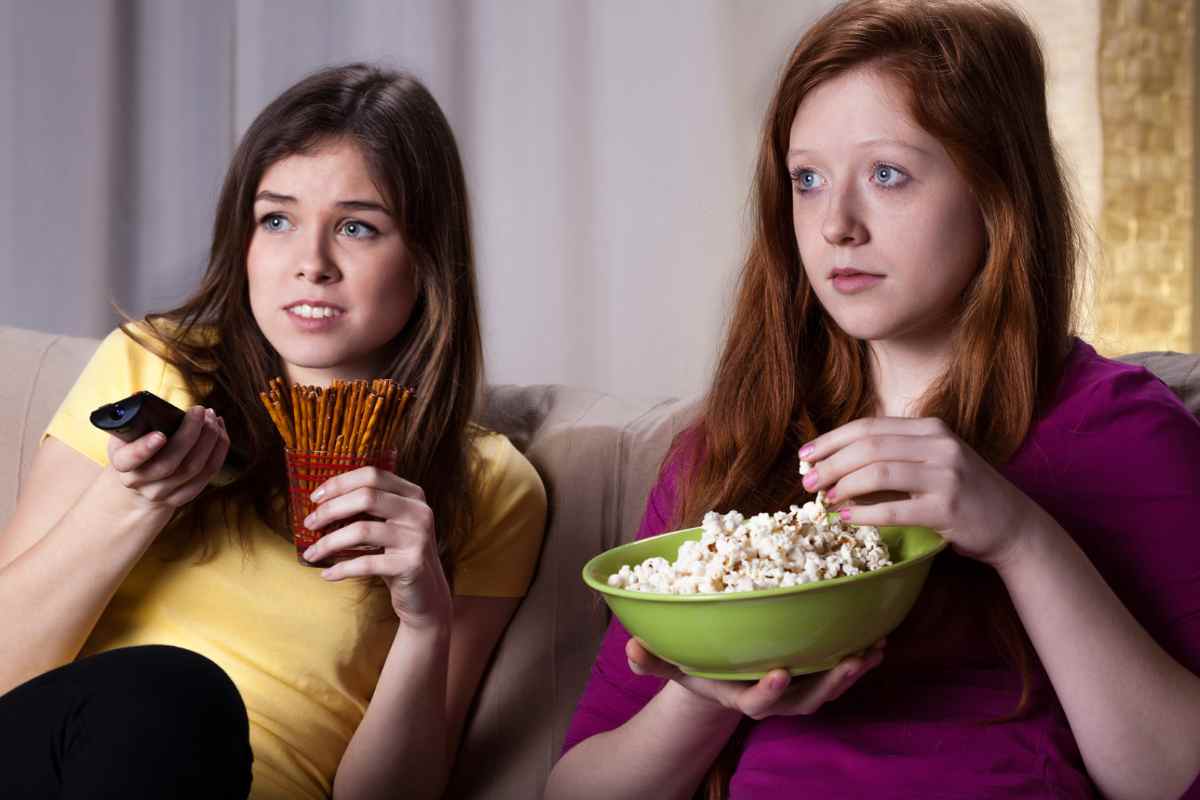 Due donne che guardano la TV con cibo