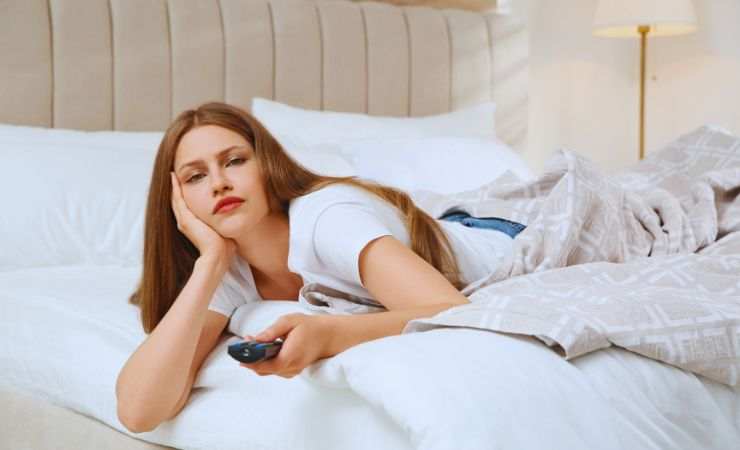 ragazza che guarda la tv dal letto