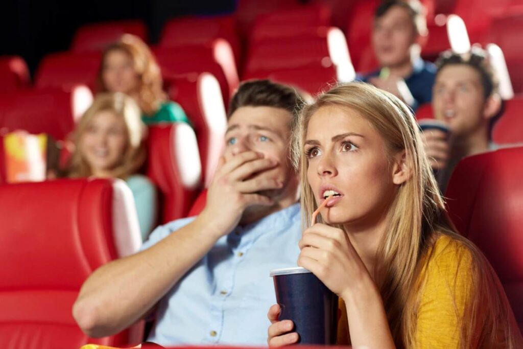 Due persone spaventate che guardano film al cinema