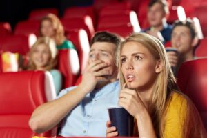 Due persone spaventate che guardano film al cinema