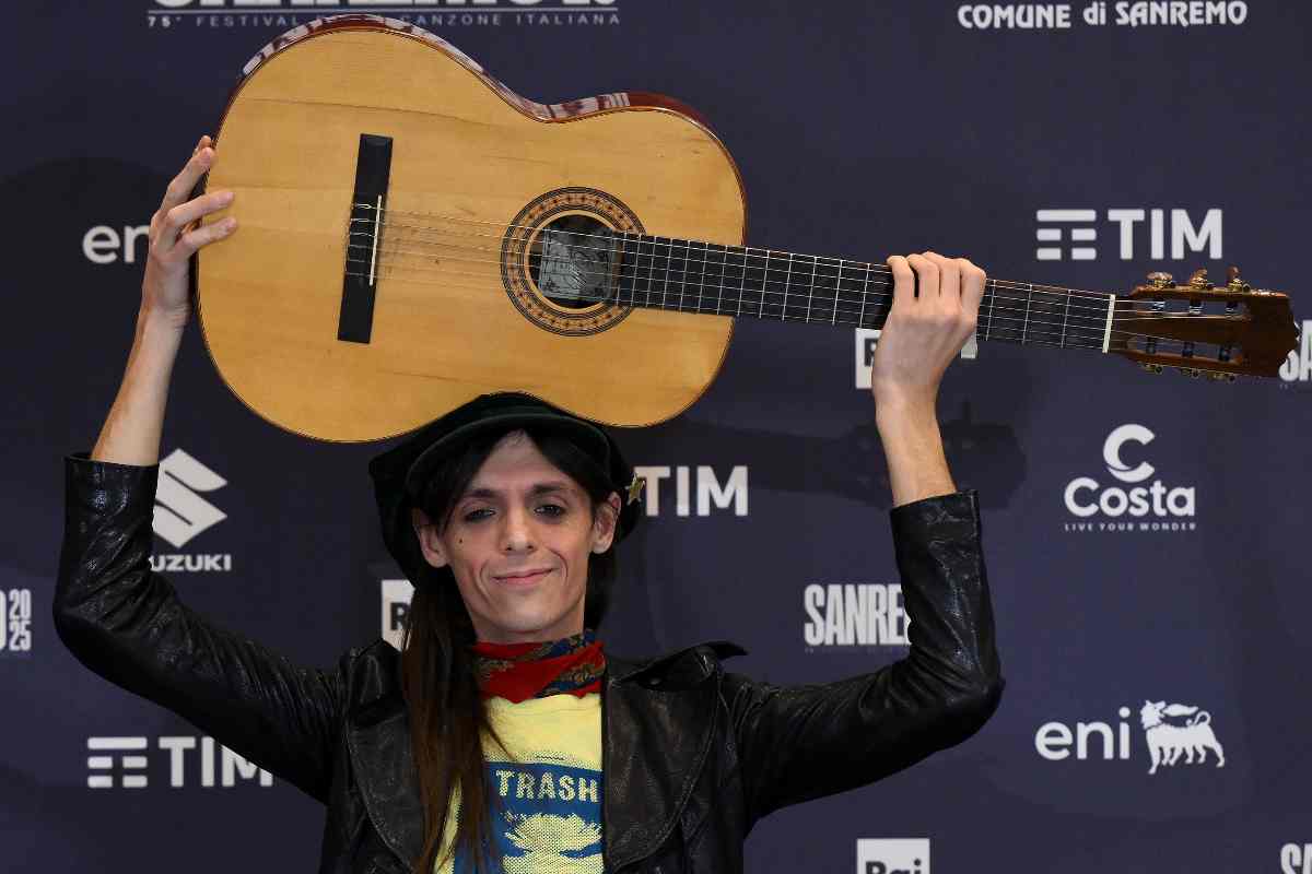 Lucio Corsi con la chitarra sopra la testa